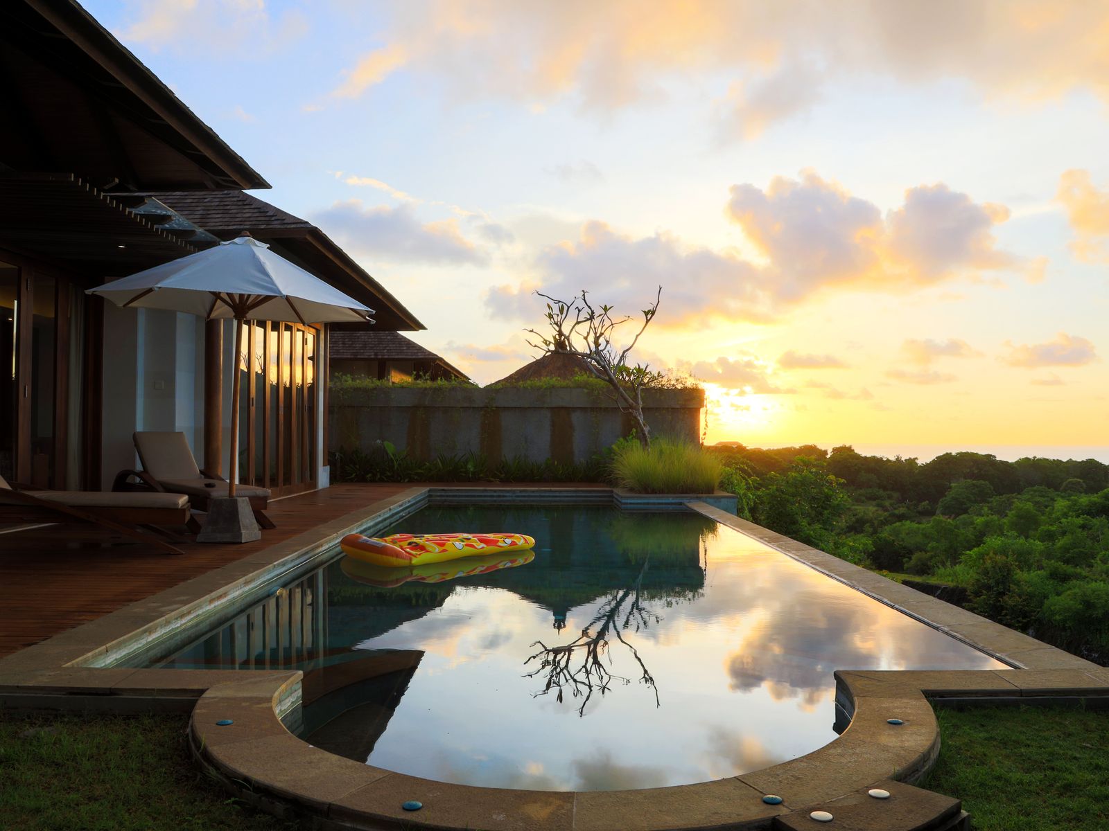 A Bali pool villa glowing at sunset